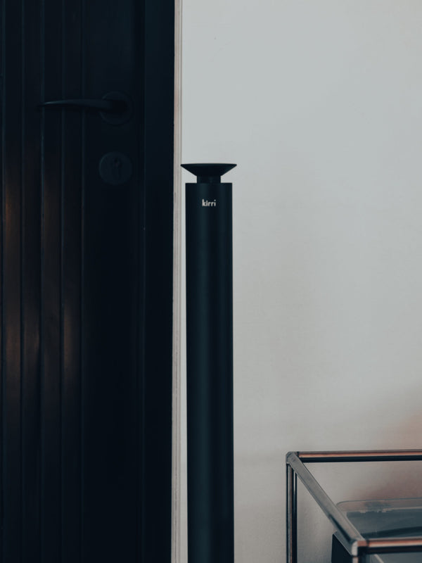 black kirri pillar diffuser standing beside a dark door frame