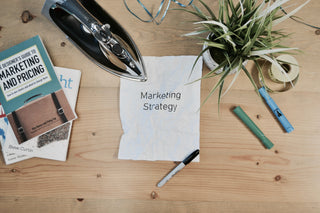 paper lay on the table that reads Marketing Strategy with accessorise on the table 