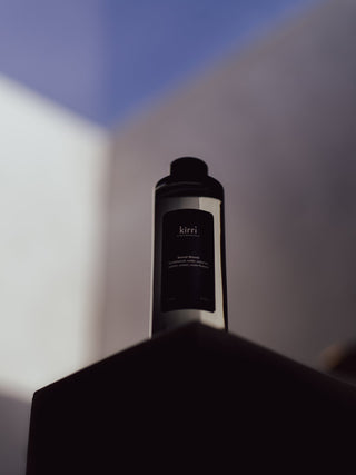 kirri fragrance oil bottle in soft daylight against a pale wall
