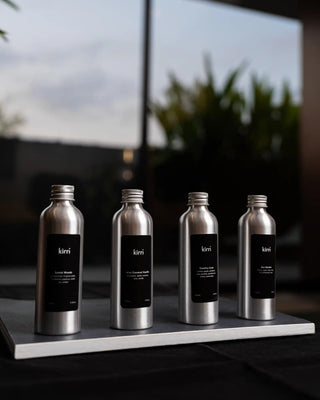 kirri aura oil bottles lined up with a garden behind