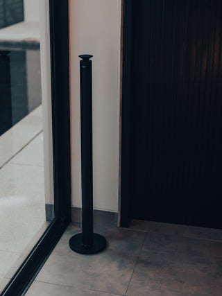 black kirri beacon diffuser in the corner of a room beside a glass wall and timber battens