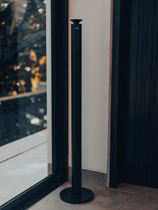 black kirri beacon diffuser by a window with warm evening lights outside