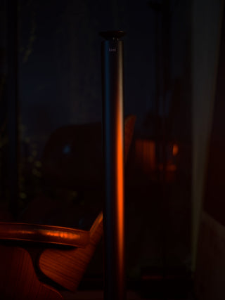 tall black kirri diffuser lit by warm amber light in a dark evening room