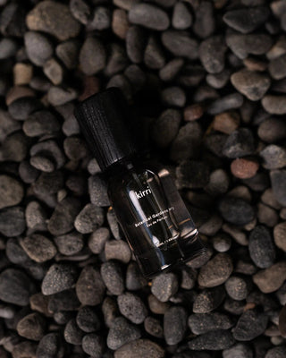 kirri fragrance oil on black pebbles