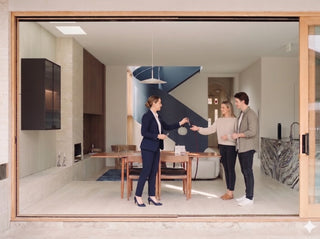 real estate agent handing keys to a couple in their new home