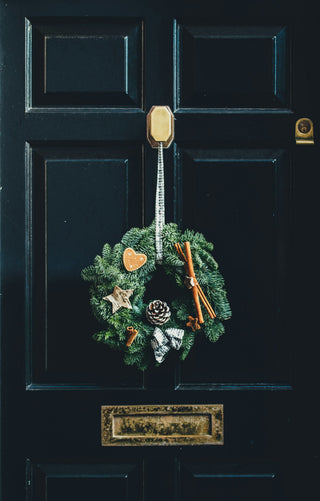 green christmas wreath hanging on a front door