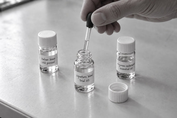 perfumer blending a signature home fragrance trial at a lab bench